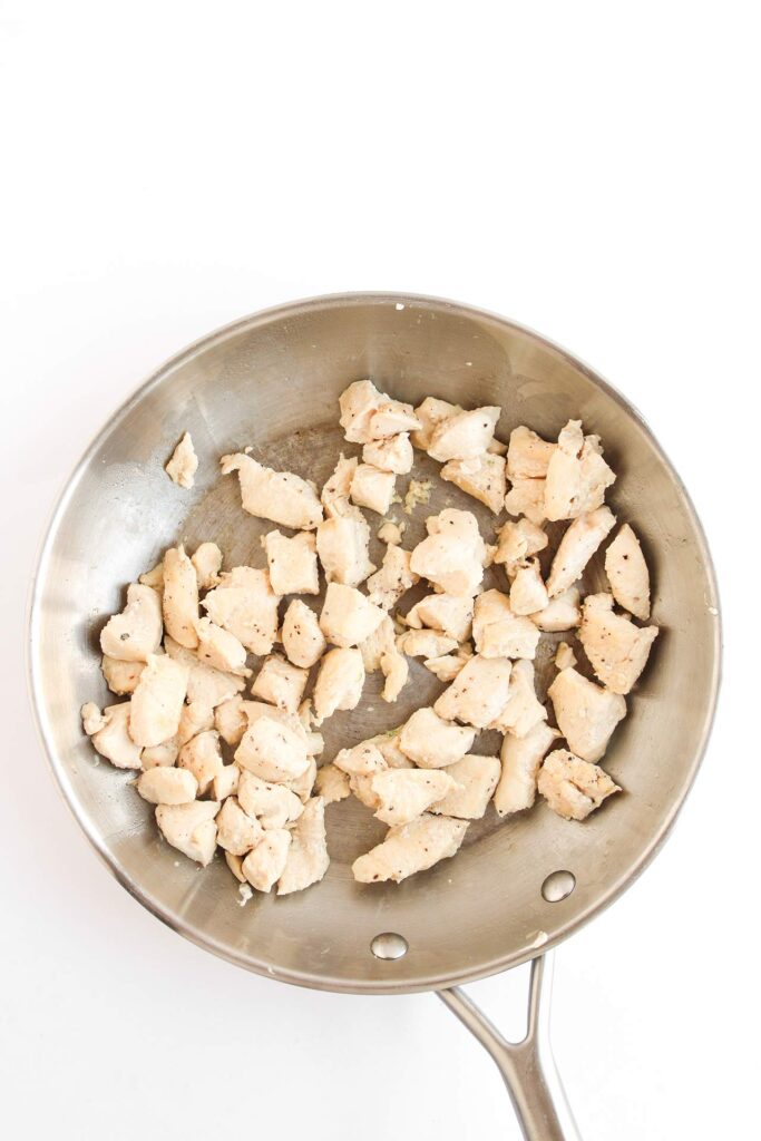 Cooked chicken chunks in a skillet.