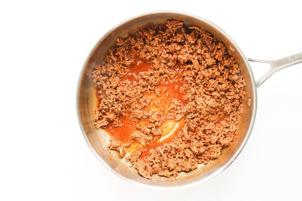 Seasoned, cooked ground beef in a skillet.