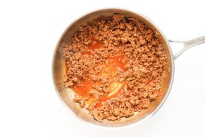 Seasoned, cooked ground beef in a skillet.