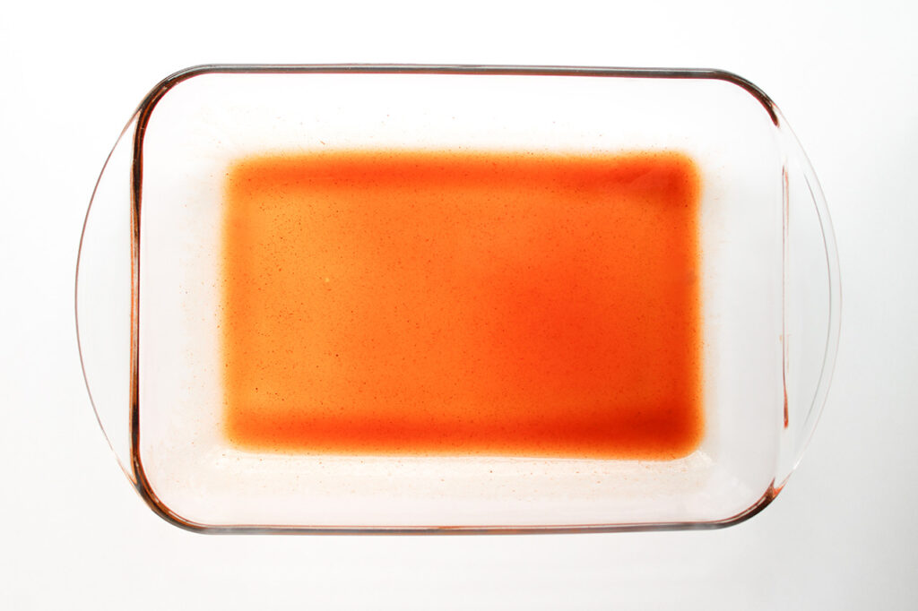 A casserole dish prepared for assembling this Beef Enchilada Casserole.