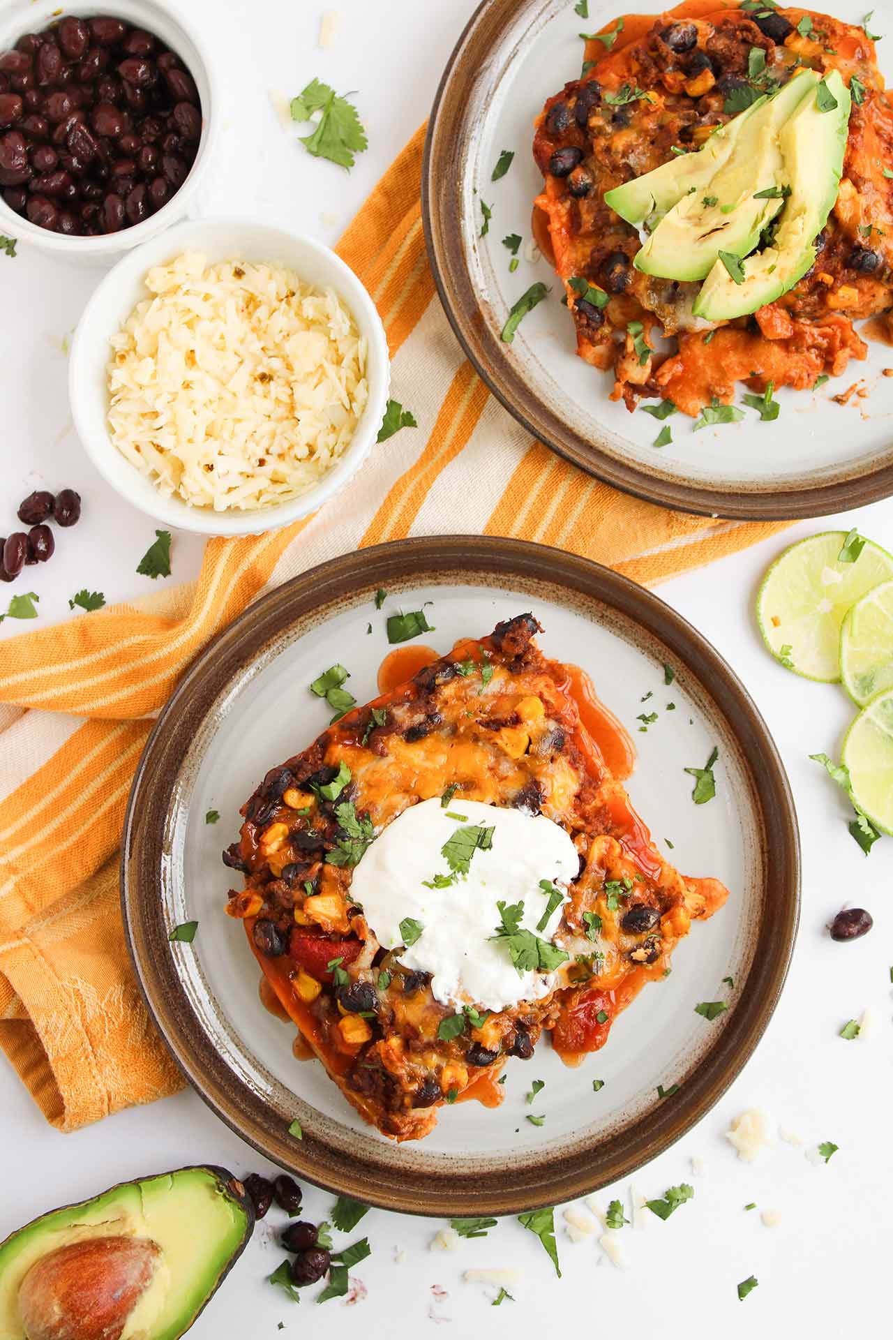 Overhead focus. Two plates with servings of Beef Enchilada Casserole on them.